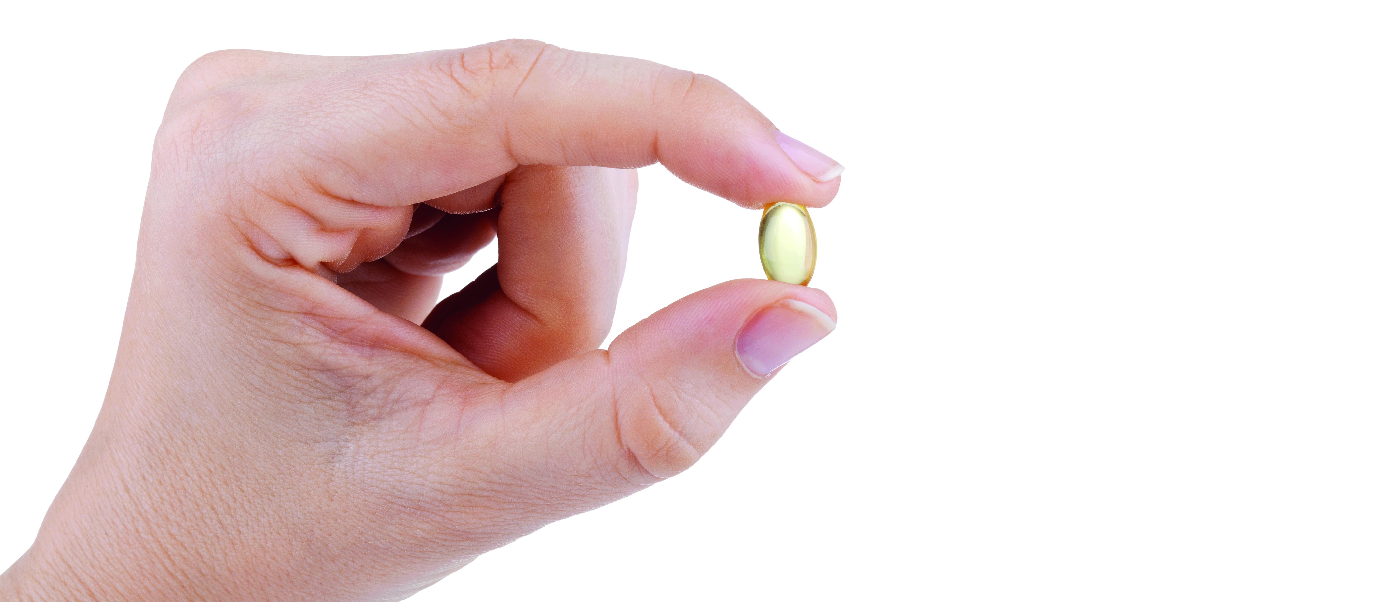 Hand holding fish oil supplement
