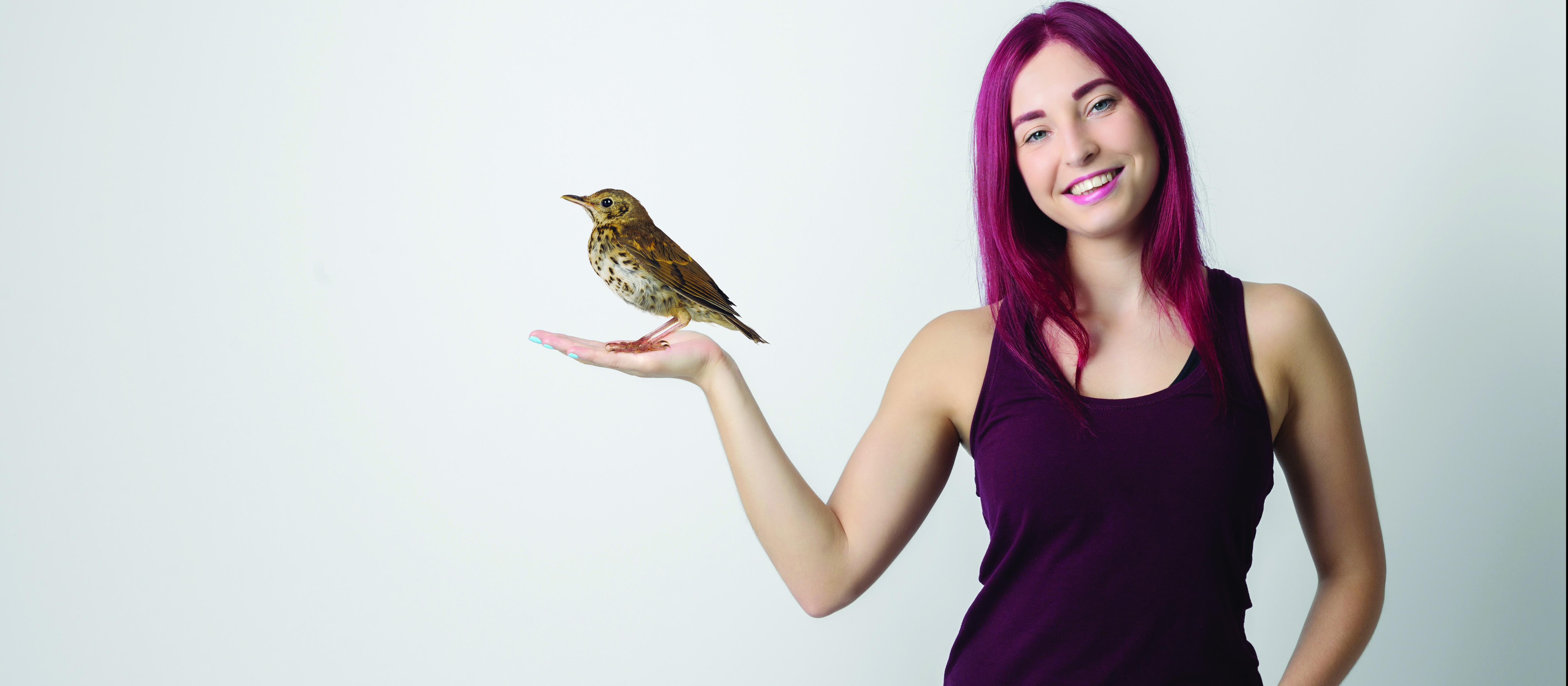 Woman holding thrush bird