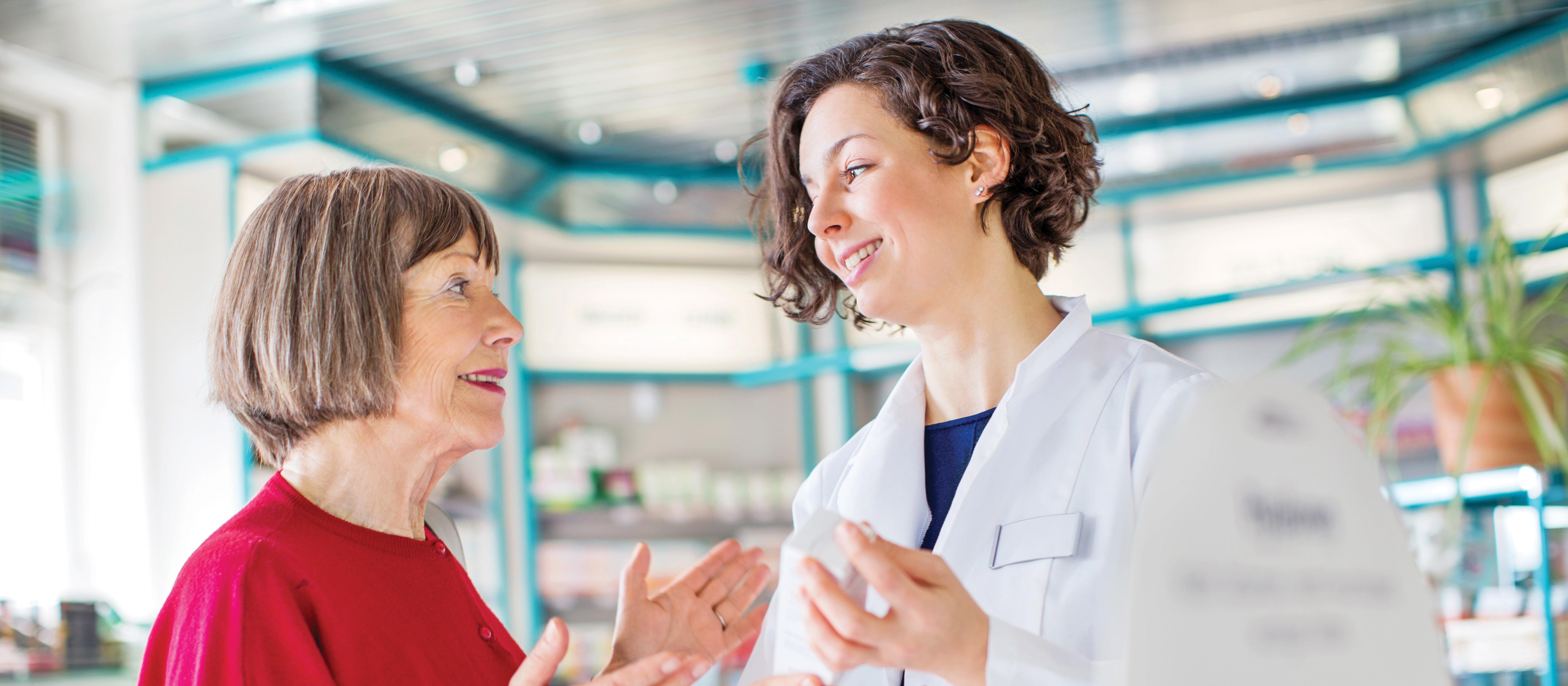 Pharmacist talking to elderly woman