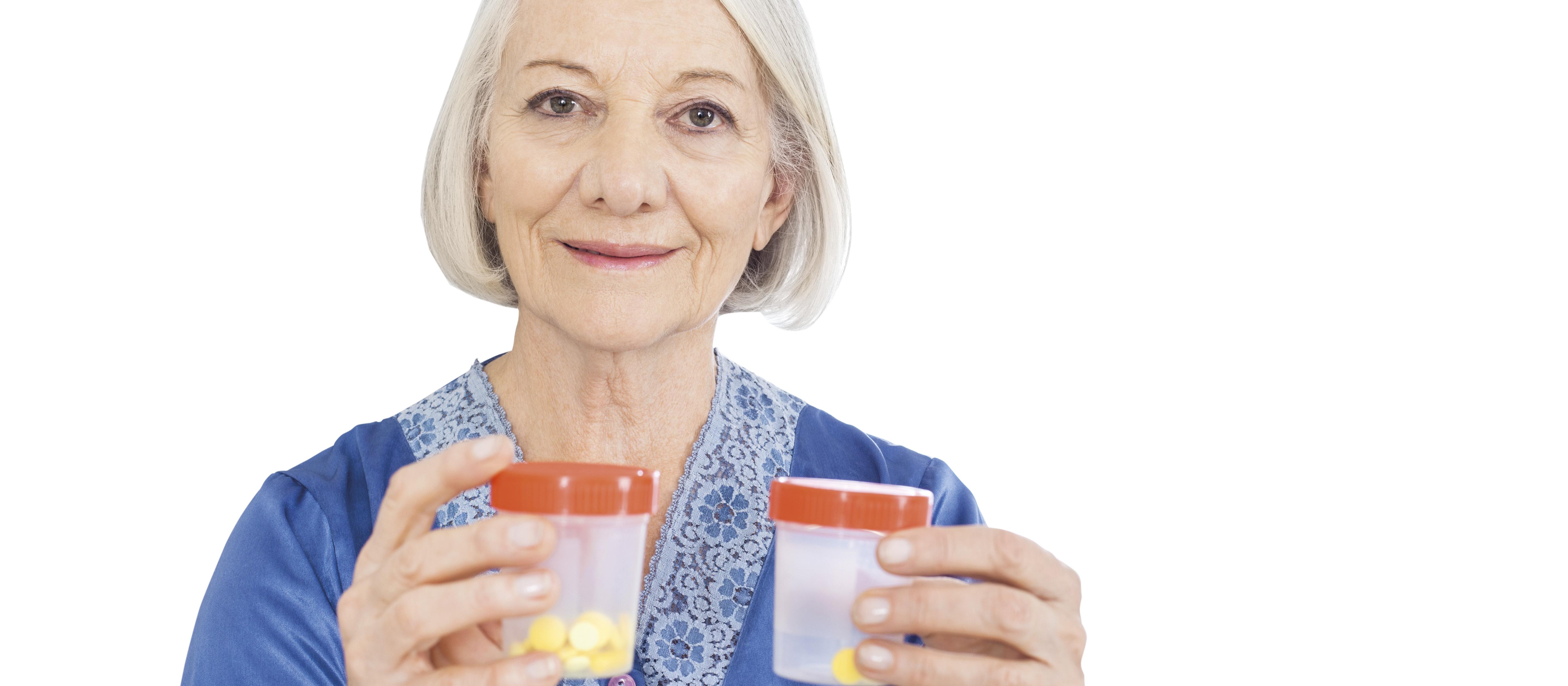 Elderly senior woman holding medicine bottles