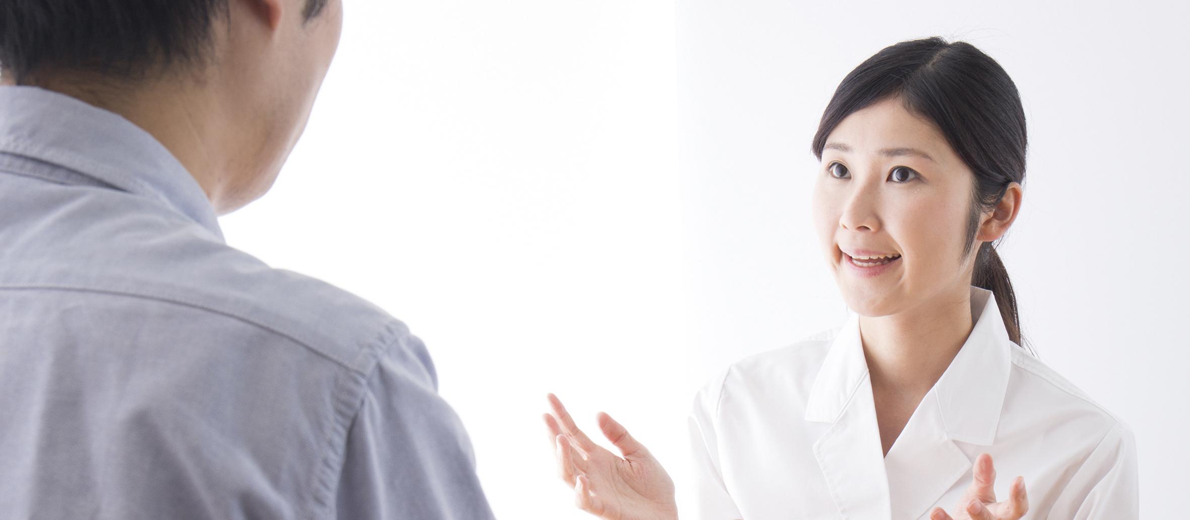 Asian female pharmacist talking to male customer