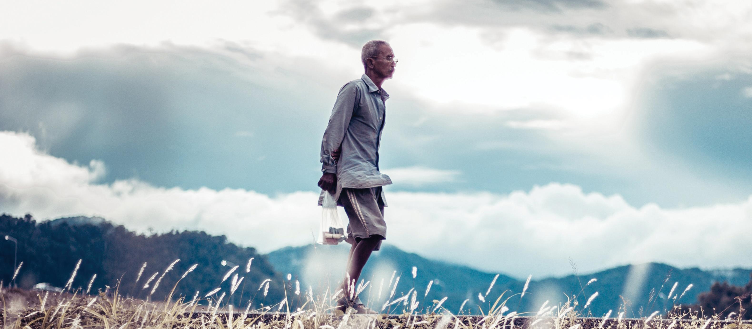 Elderly asian man walking along. unsplash.com