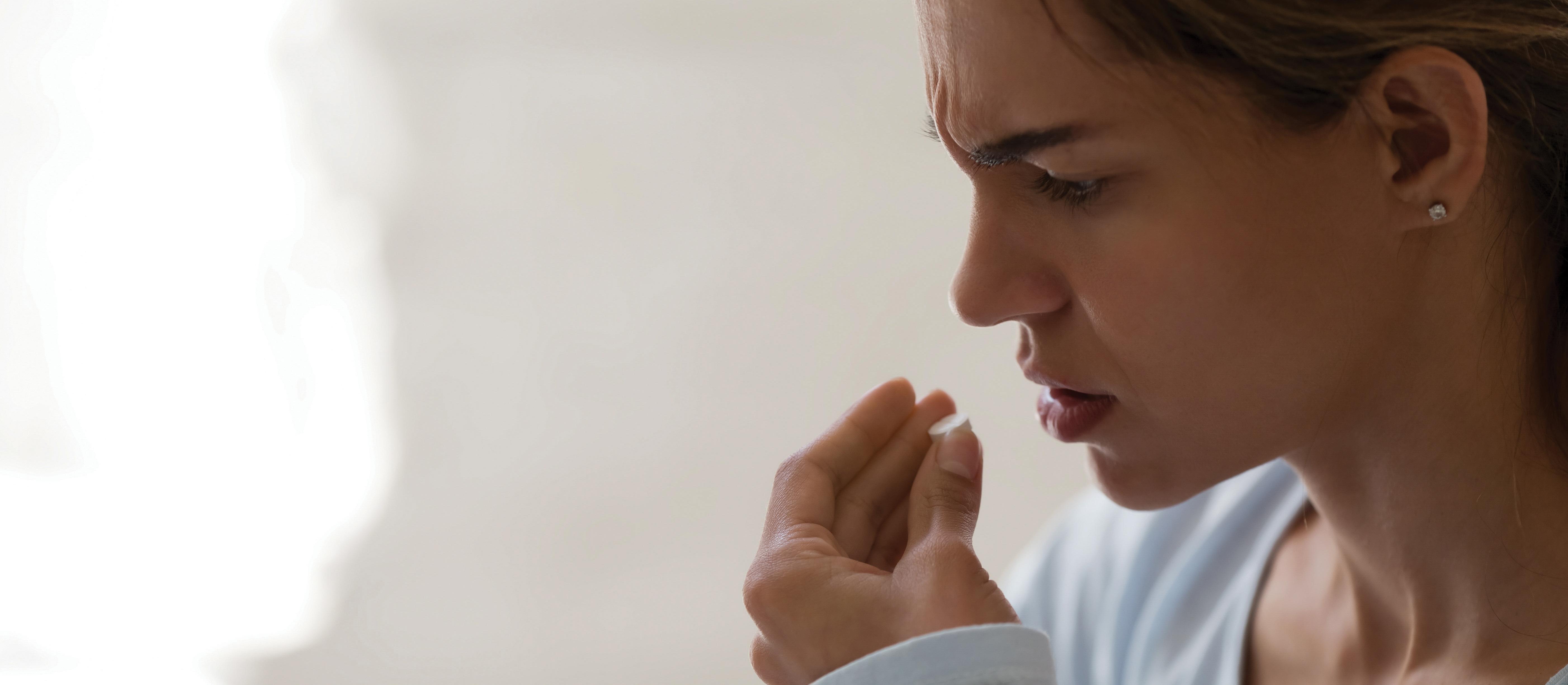 Distress woman taking medicine pill 