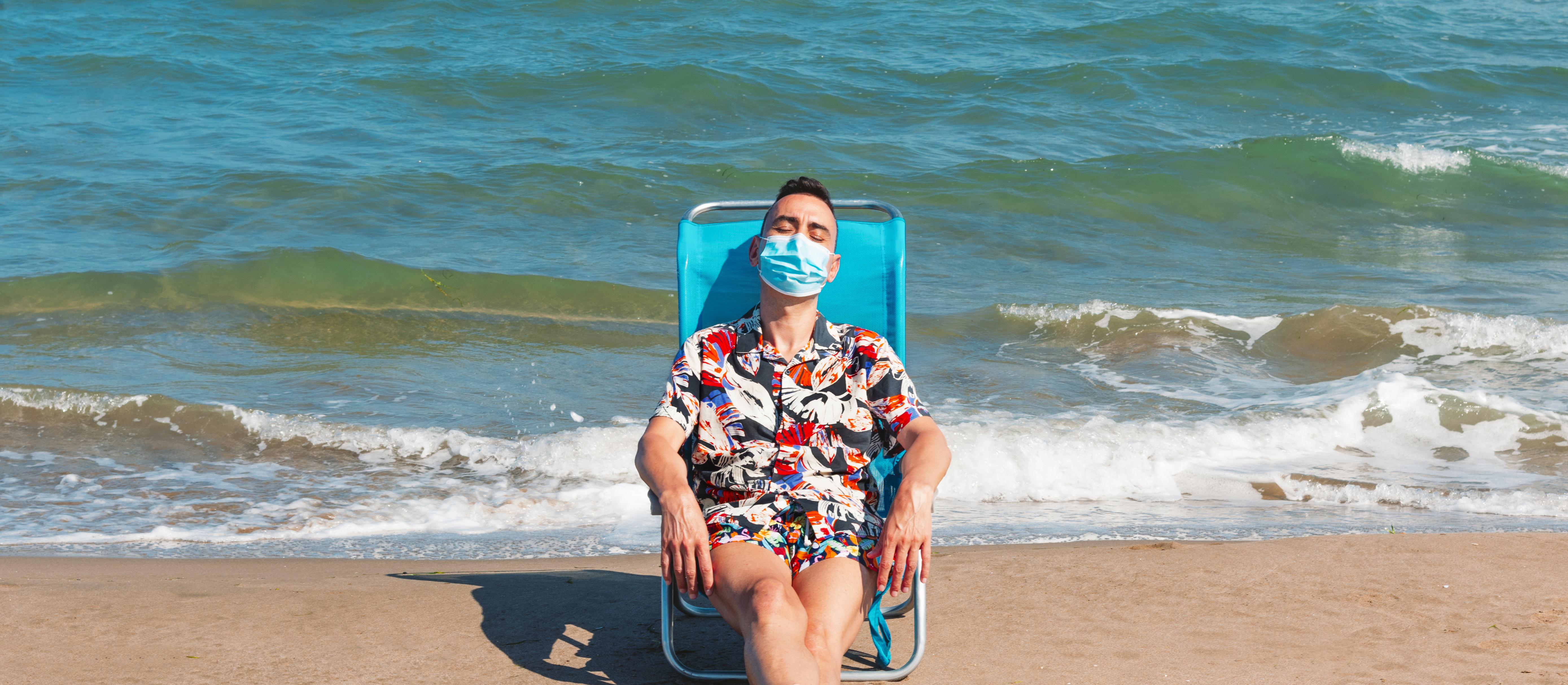 Man relaxing on a beach with mask
