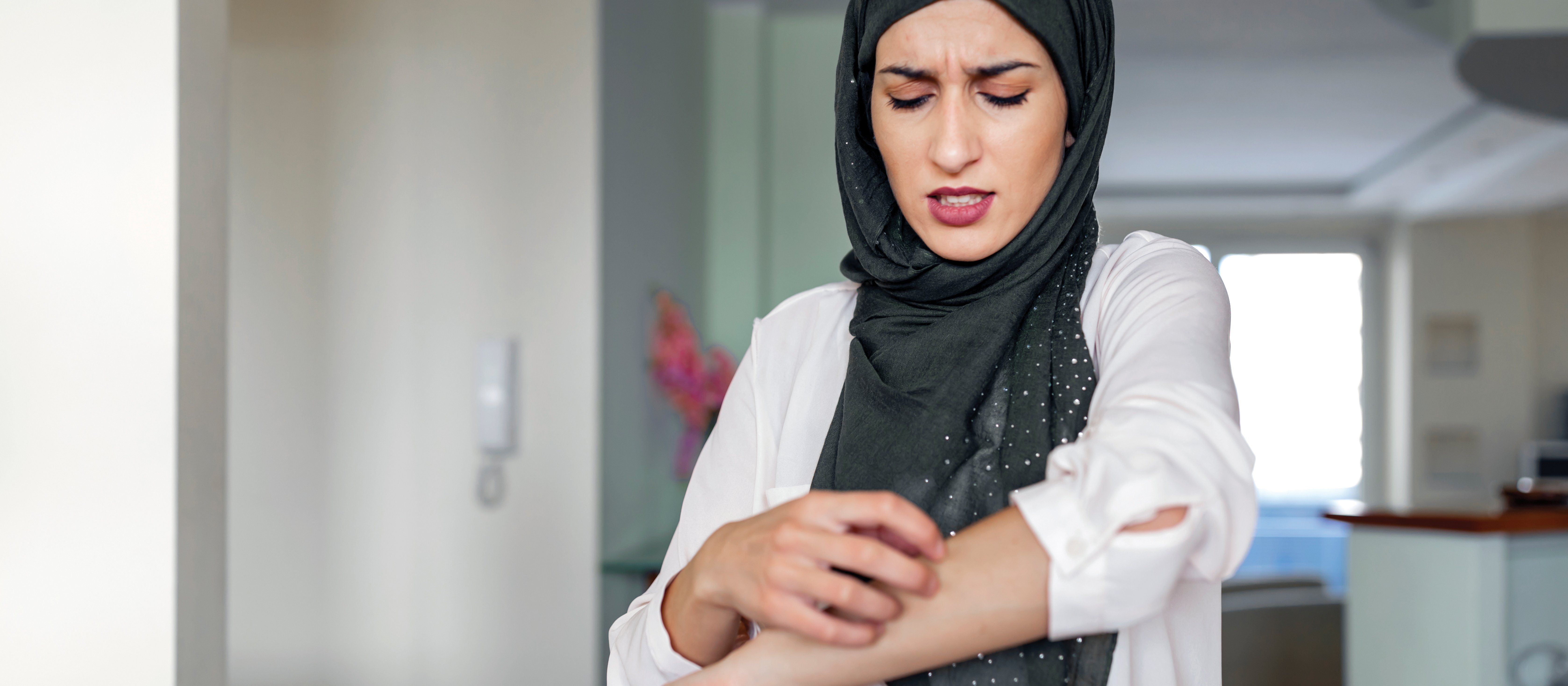 Woman scratching arm