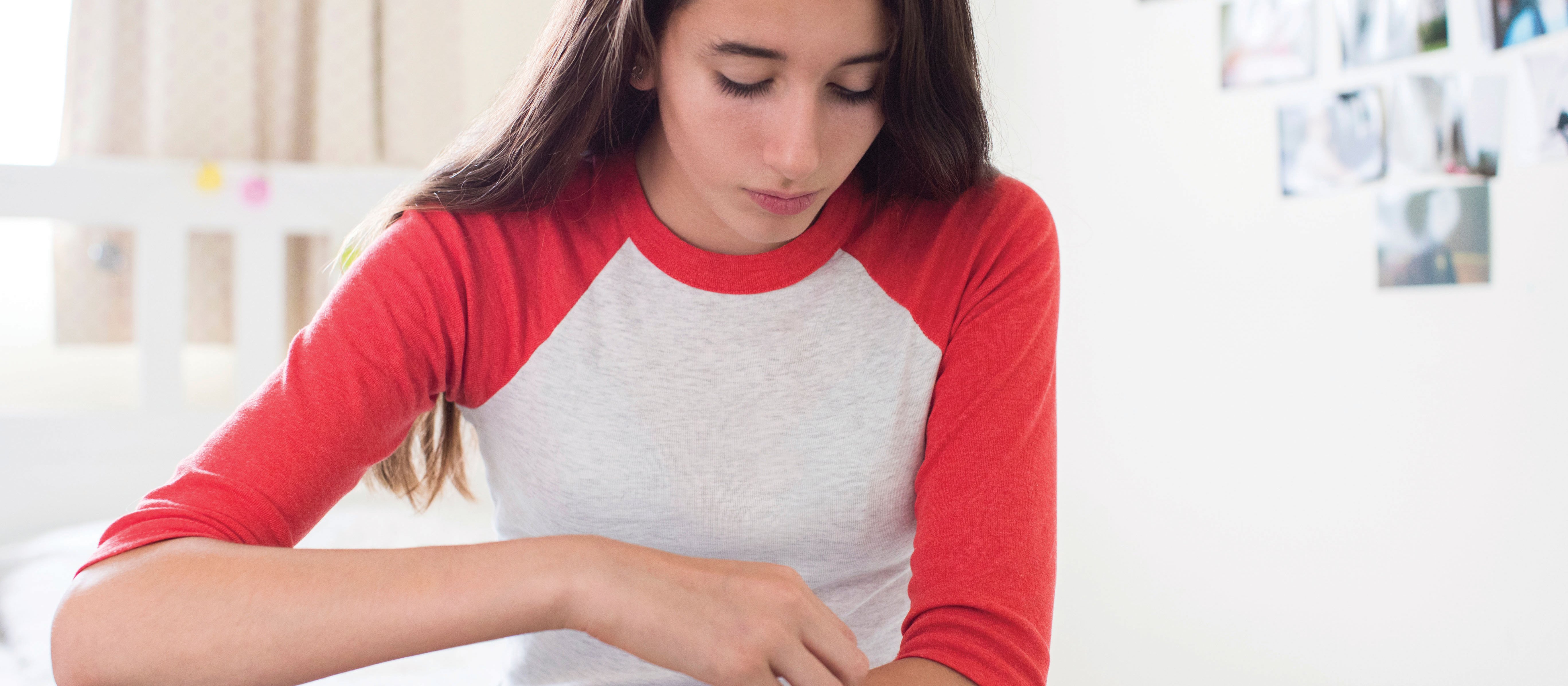 Young teen girl scratching arm