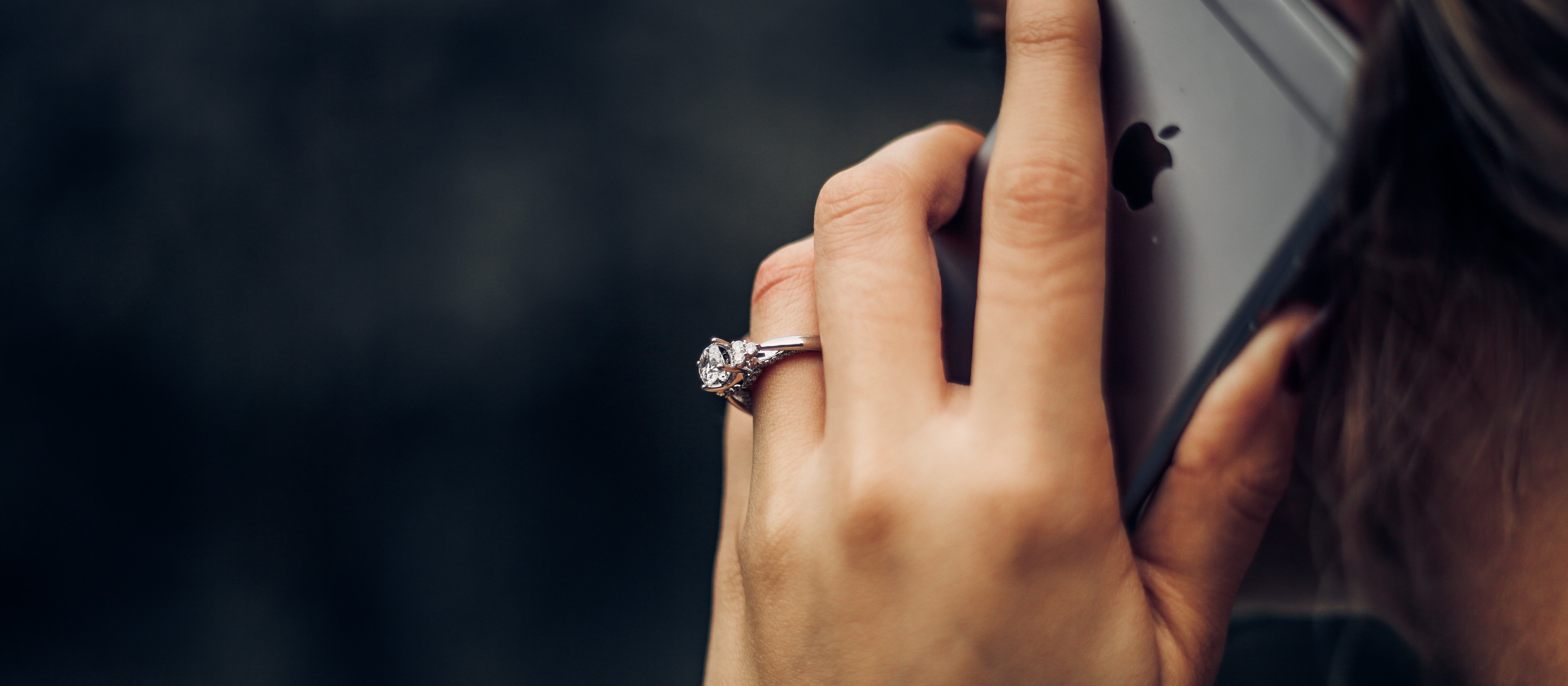 Close up of woman's hand holding an iPhone to her ear