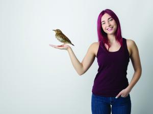 Woman holding thrush bird