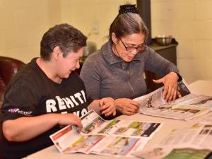 Volunteers making newspaper bags