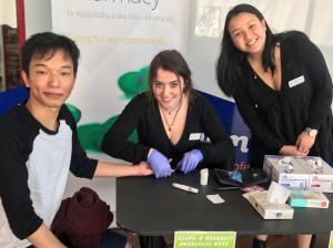 Otago pharmacy students Laura Pidcock (centre) and Nadine King offer a blood glucose test to Dunedin resident Van Chanusorn