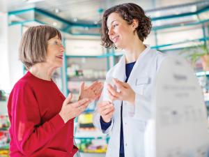 Pharmacist talking to elderly woman