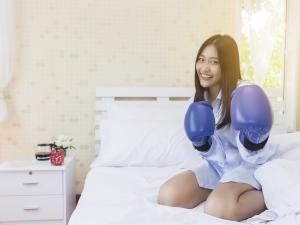 Asian woman boxing glove bedroom