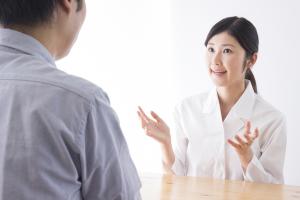 Asian female pharmacist talking to male customer
