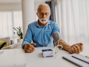 Elderly man measuring blood pressure 