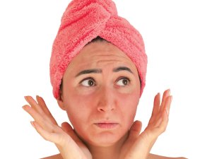 Woman with red face and hair wrapped in a towel