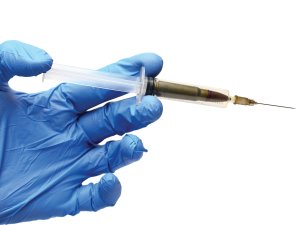 Hand holding syringe