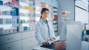 Asian pharmacist at computer