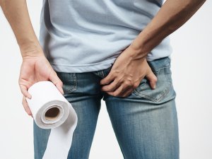 Man with toilet paper suffering from hemorrhoid