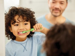 Father son brushing teeth