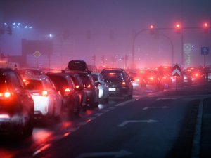 A line of cars in a traffic jam with smog haze