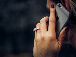 Close up of woman's hand holding an iPhone to her ear